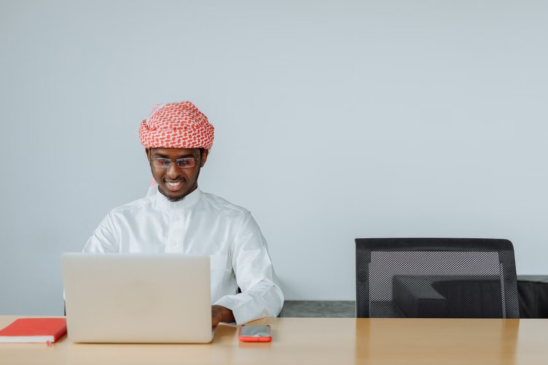 مدير خليجي بالثوب يراجع العمل من الحاسوب